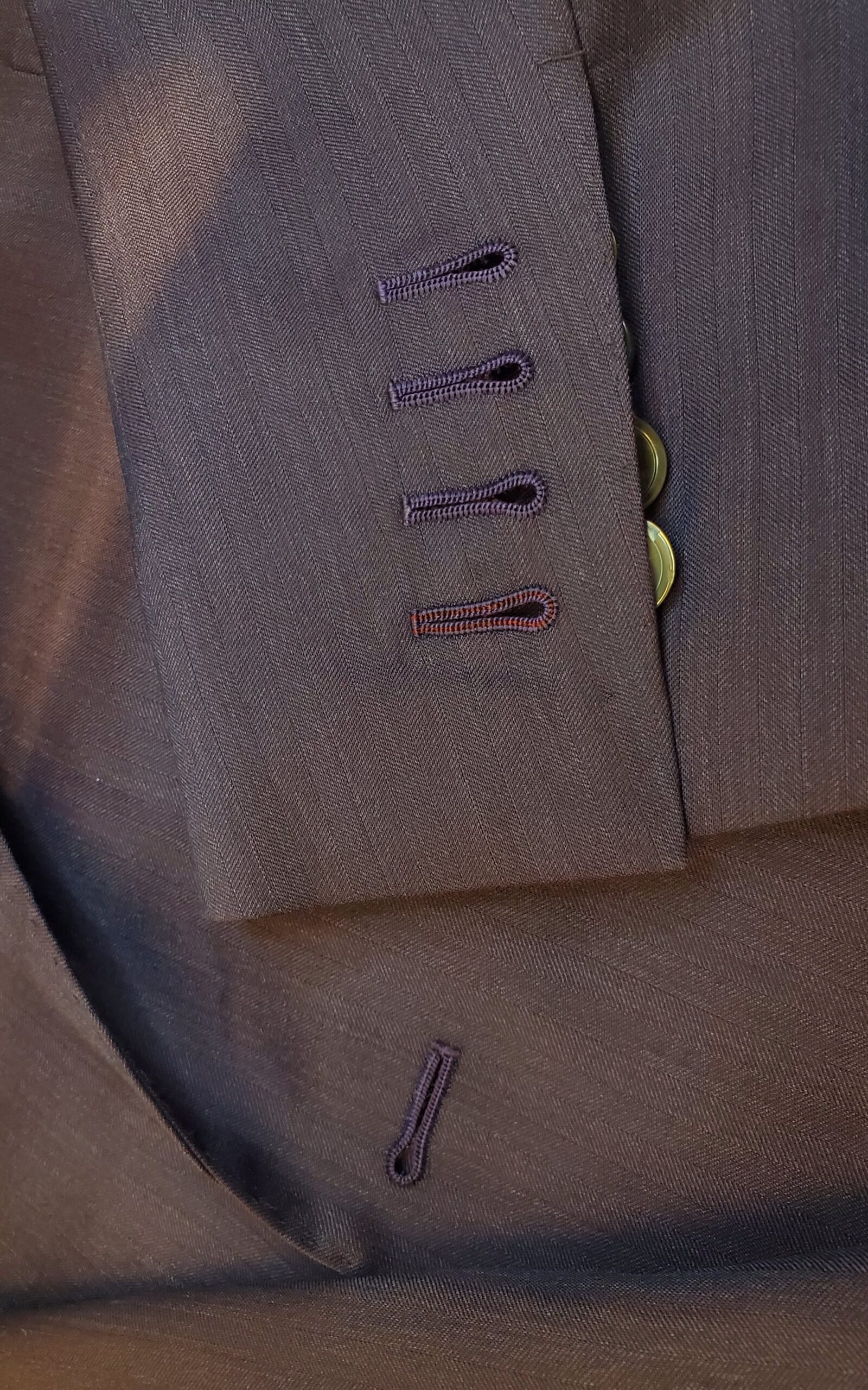 4 hand-sewn buttonholes with contrast thread in one buttonhole