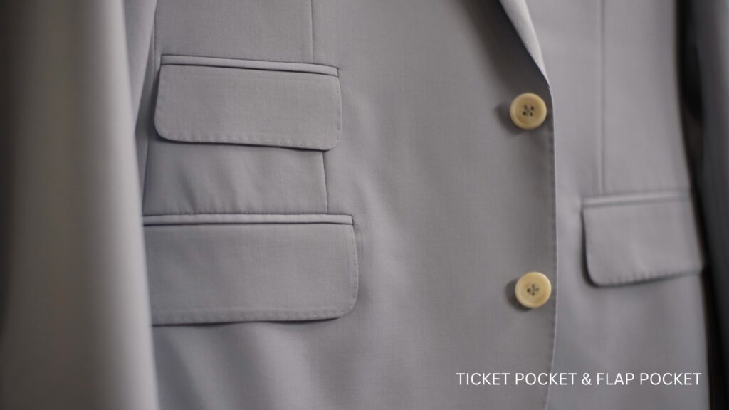 images shows a blue suit with a ticket pocket and flap pocket 